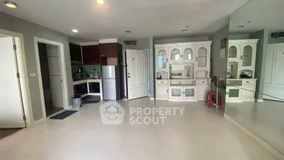 Spacious living room with elegant cabinetry and mirrored wall in modern apartment.