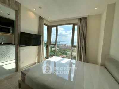 Modern bedroom with stunning city and sea view, featuring large windows and sleek interior design.