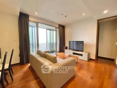 Modern living room with cozy sofa and large TV, featuring a balcony view.