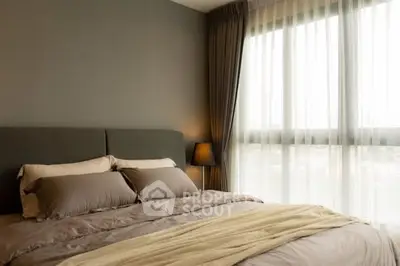 Cozy bedroom with elegant decor and large window for natural light.