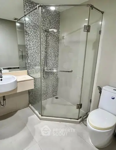 Modern bathroom with glass shower enclosure and sleek fixtures