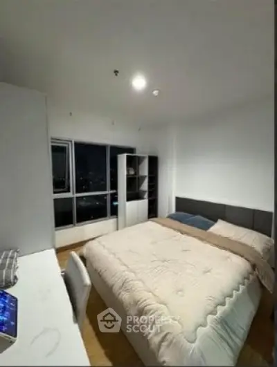 Modern bedroom with large window and cozy bed in high-rise apartment