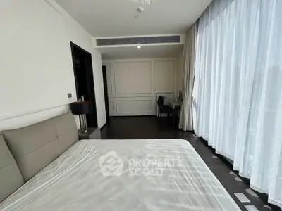 Spacious bedroom with elegant decor and large windows for natural light