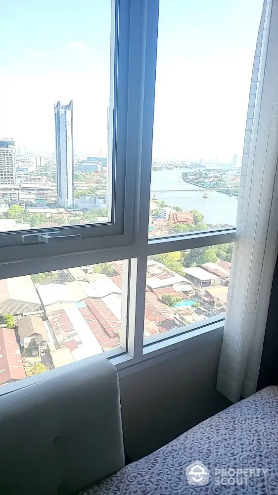 Stunning high-rise apartment view overlooking cityscape and river, perfect for urban living.