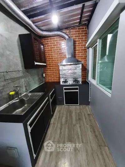 Modern kitchen with sleek design, featuring gas stove and stainless steel sink, perfect for culinary enthusiasts.