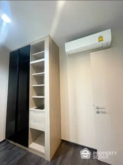 Modern minimalist bedroom with sleek built-in wardrobe and efficient air conditioning, perfect for urban living.