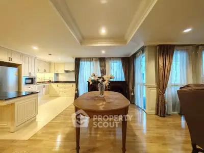 Spacious open-layout kitchen and dining area with elegant wooden flooring and natural light.