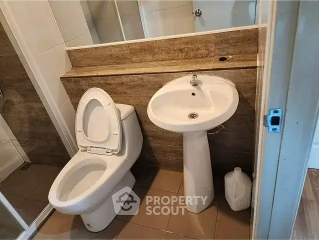 Modern bathroom with sleek fixtures and neutral tones, featuring a compact design for efficient space use.
