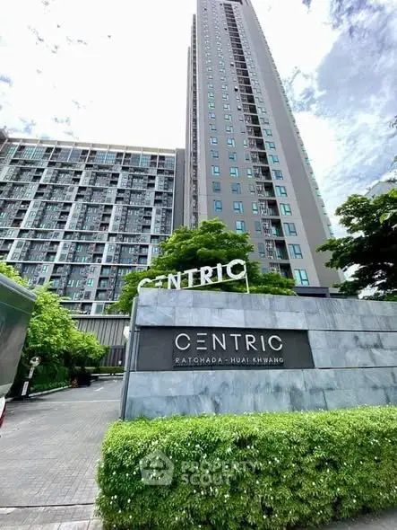 Modern high-rise condominium with lush greenery at Centric Ratchada-Huai Khwang.