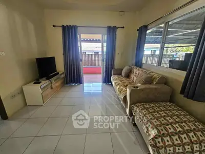 Spacious living room with modern decor and large windows leading to a balcony.