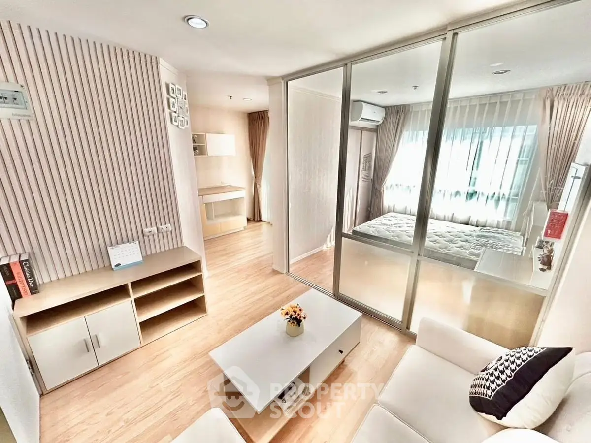 Modern open-plan living room with glass partition and cozy bedroom