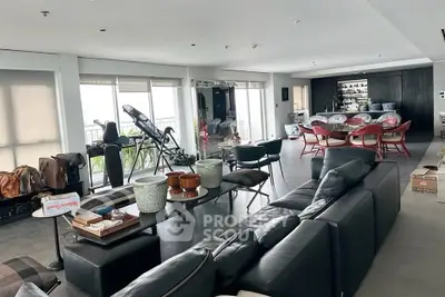 Spacious modern living room with sleek furniture and dining area, perfect for entertaining.
