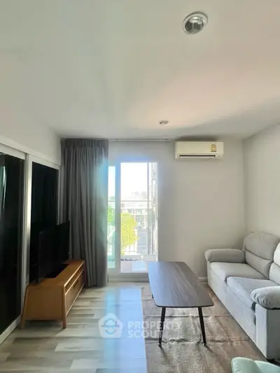 Bright and modern living room with balcony view, featuring sleek furniture and natural light.