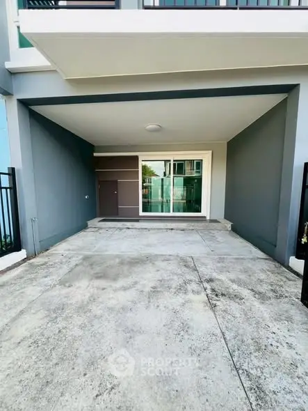 Modern residential building entrance with spacious parking area and sleek design.