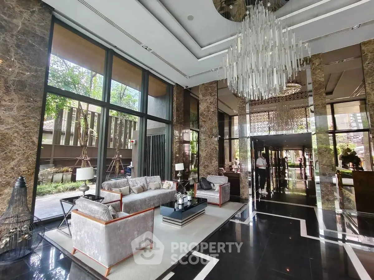 Luxurious modern living room with elegant chandelier and floor-to-ceiling windows.