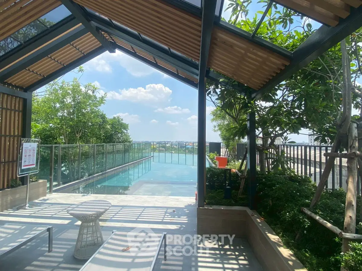 Stunning rooftop pool with panoramic city views and lush greenery.