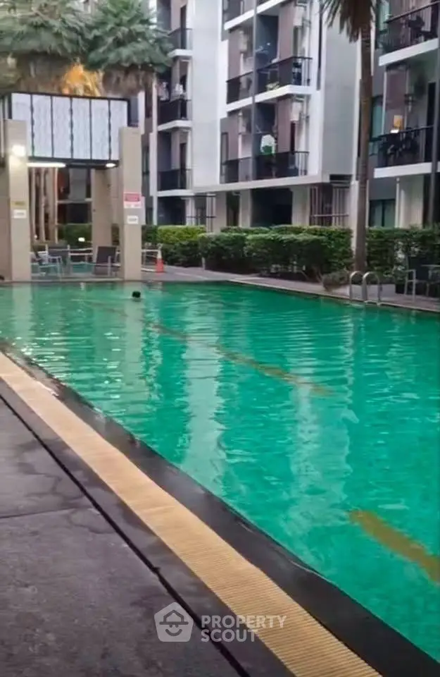Luxurious apartment complex with inviting swimming pool and modern architecture.