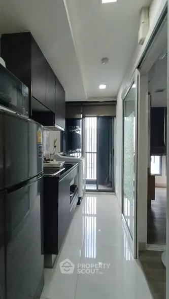 Modern kitchen with sleek cabinets and stainless steel appliances in a stylish apartment.