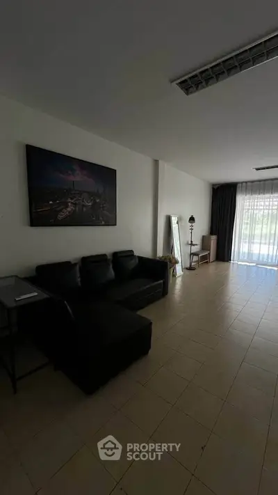 Spacious living room with modern decor and large window for natural light.