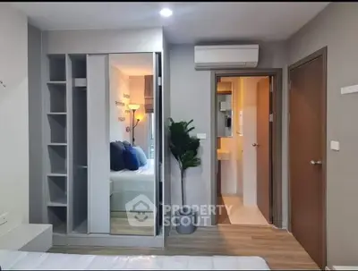 Modern bedroom with mirrored wardrobe and ensuite bathroom in stylish apartment.