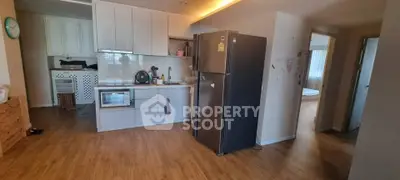 Modern kitchen with sleek cabinetry and stainless steel appliances in open layout apartment.