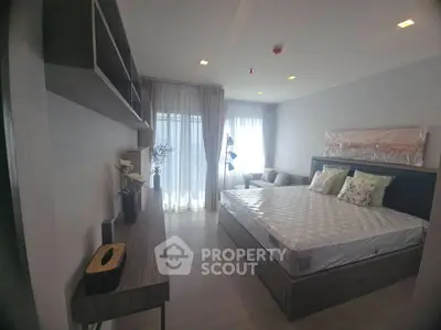 Modern bedroom with stylish decor and natural light, featuring a comfortable bed and elegant furnishings.