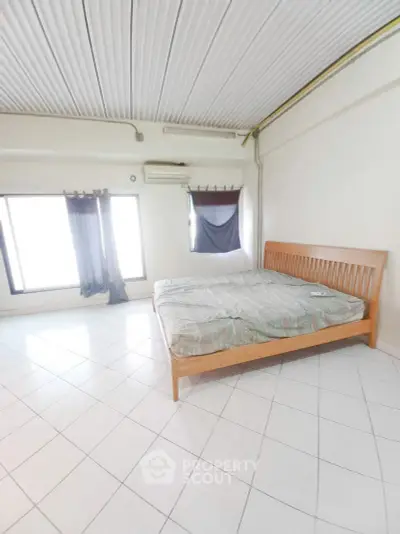 Spacious bedroom with large windows and minimalist decor