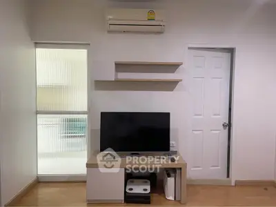 Modern living room with TV, air conditioning, and minimalist decor