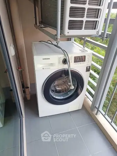 Compact balcony with washing machine and air conditioning unit, ideal for urban living.