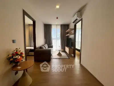 Modern living room with stylish decor and natural light, featuring a cozy sofa and elegant furnishings.