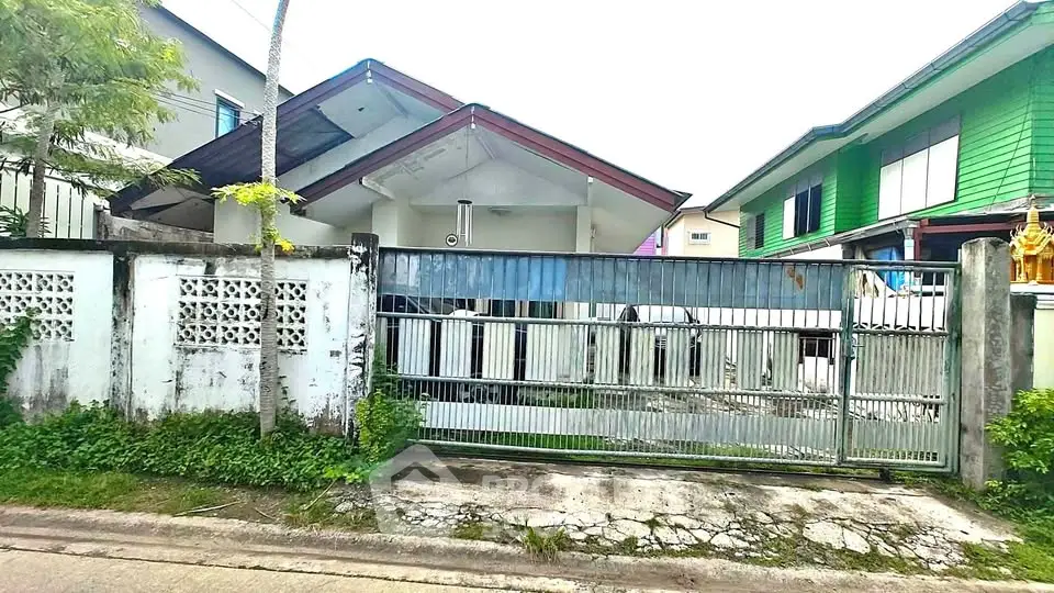 Charming suburban house with gated entrance and lush greenery, perfect for family living.