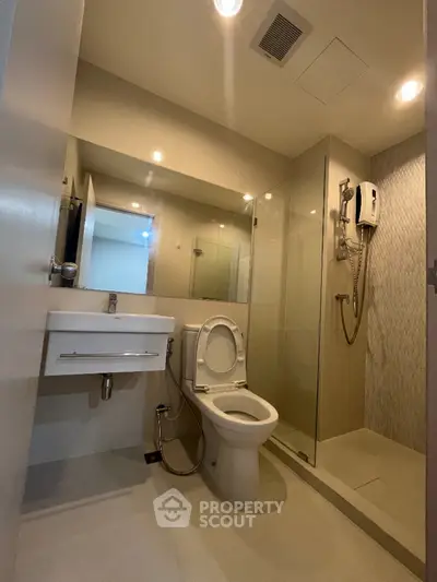Modern bathroom with glass shower and sleek fixtures in contemporary apartment