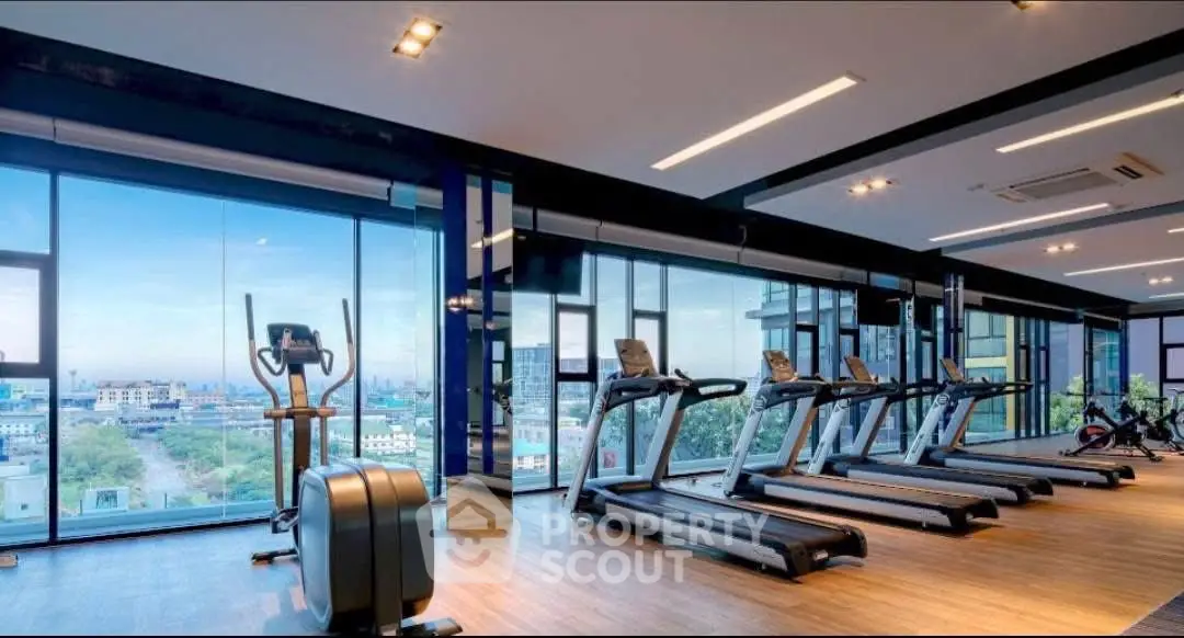 Spacious modern gym with panoramic city views and state-of-the-art equipment.