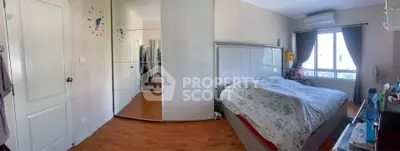 Spacious bedroom with mirrored wardrobe and large window for natural light