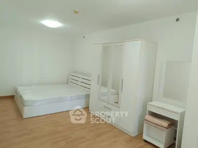 Spacious bedroom with modern white furniture and wooden flooring