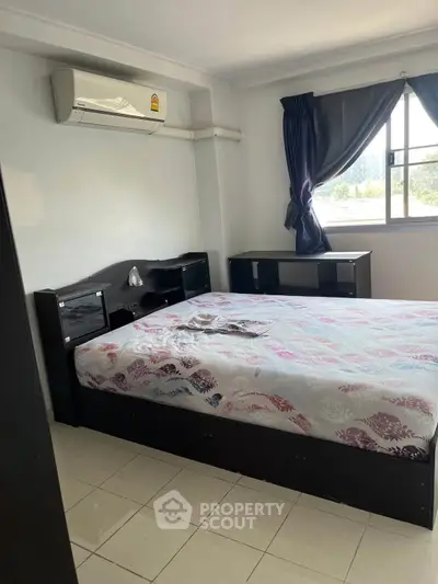 Cozy bedroom with air conditioning and natural light, featuring a comfortable bed and modern furnishings.