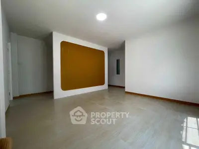 Spacious empty room with modern design and large window for natural light.