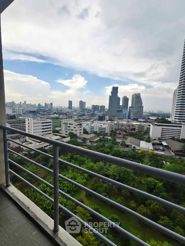 Stunning cityscape view from a high-rise balcony overlooking lush greenery and modern skyscrapers.