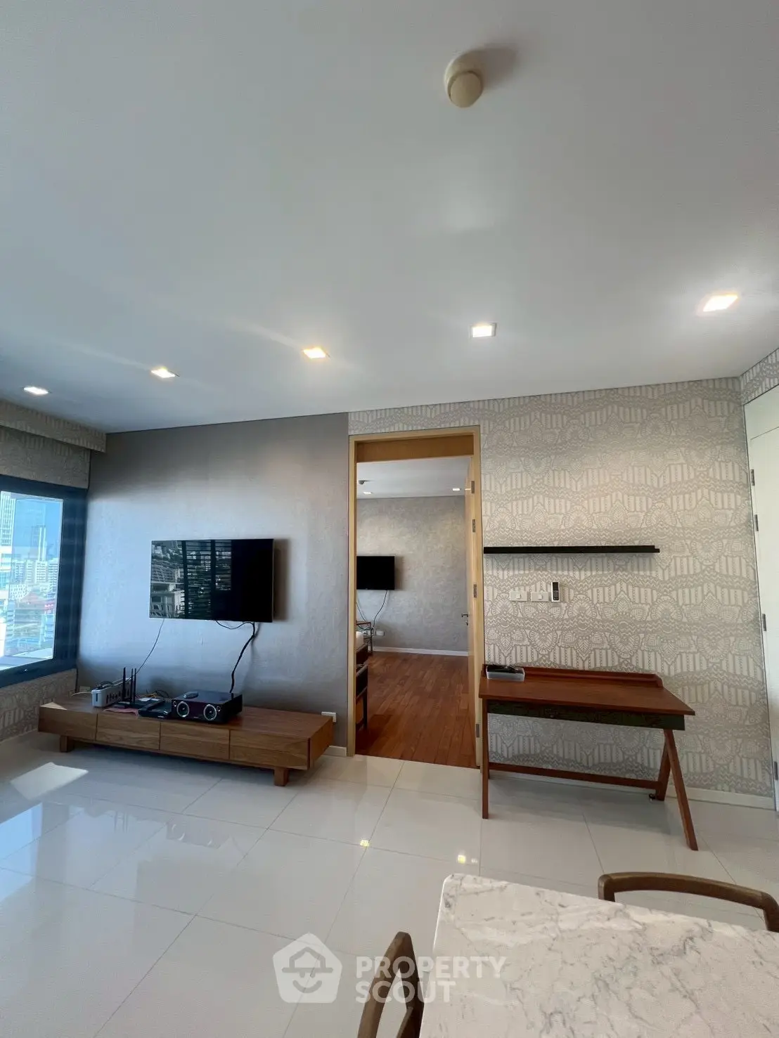 Modern living room with sleek design and city view, featuring stylish furniture and elegant decor.