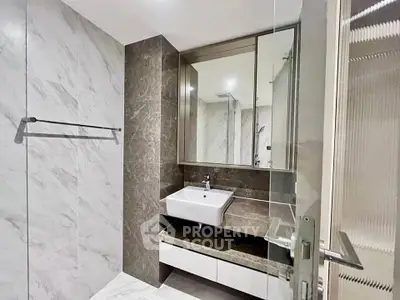 Modern bathroom with sleek design, featuring a large mirror and elegant sink in a luxurious setting.