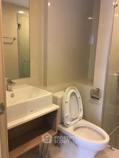Modern bathroom with sleek fixtures and glass shower enclosure.