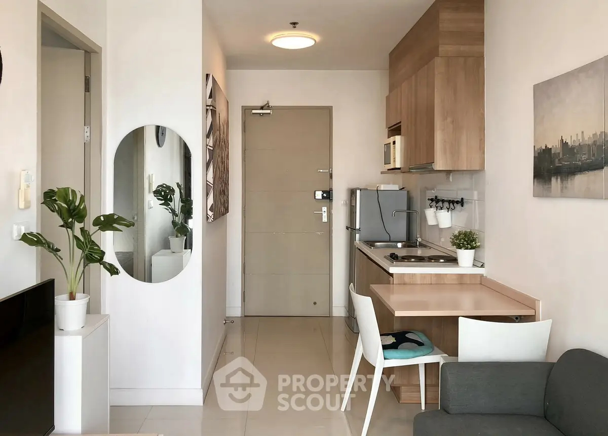 Modern compact kitchen with wooden cabinets and cozy dining area in a stylish apartment.