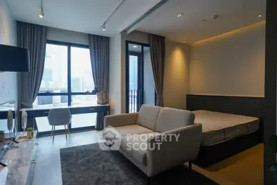 Modern studio apartment with city view, featuring a cozy living area and stylish decor.