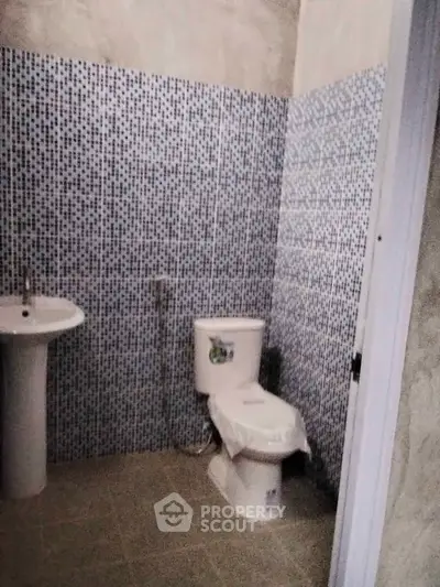 Modern bathroom with mosaic tile walls and sleek fixtures