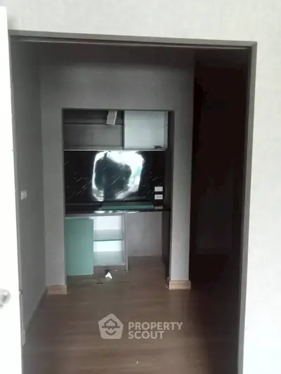 Compact storage room with built-in shelves and wooden flooring