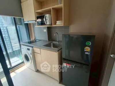 Modern compact kitchen with appliances and city view, ideal for urban living.
