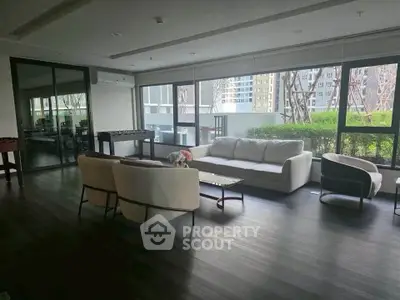 Spacious modern living room with large windows and elegant furniture in a high-rise building.