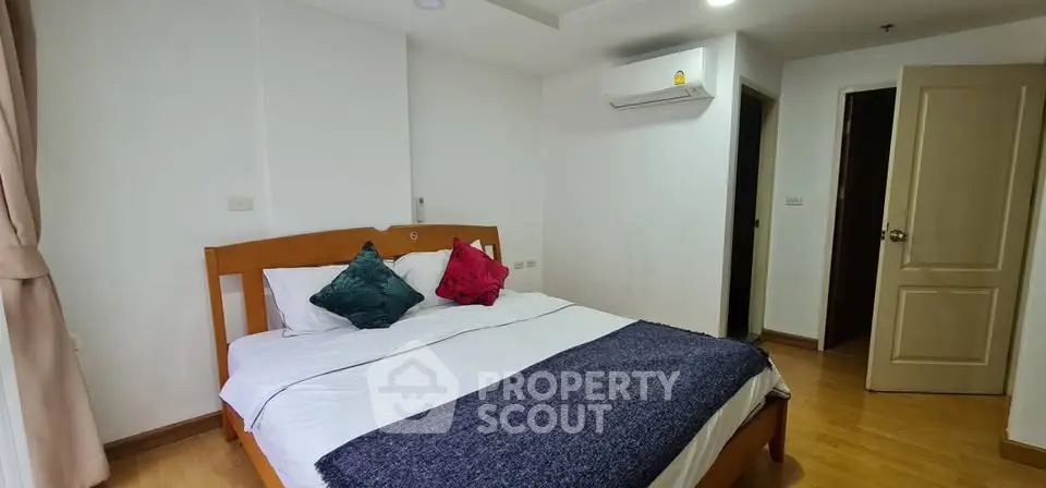 Cozy bedroom with wooden flooring and modern air conditioning unit