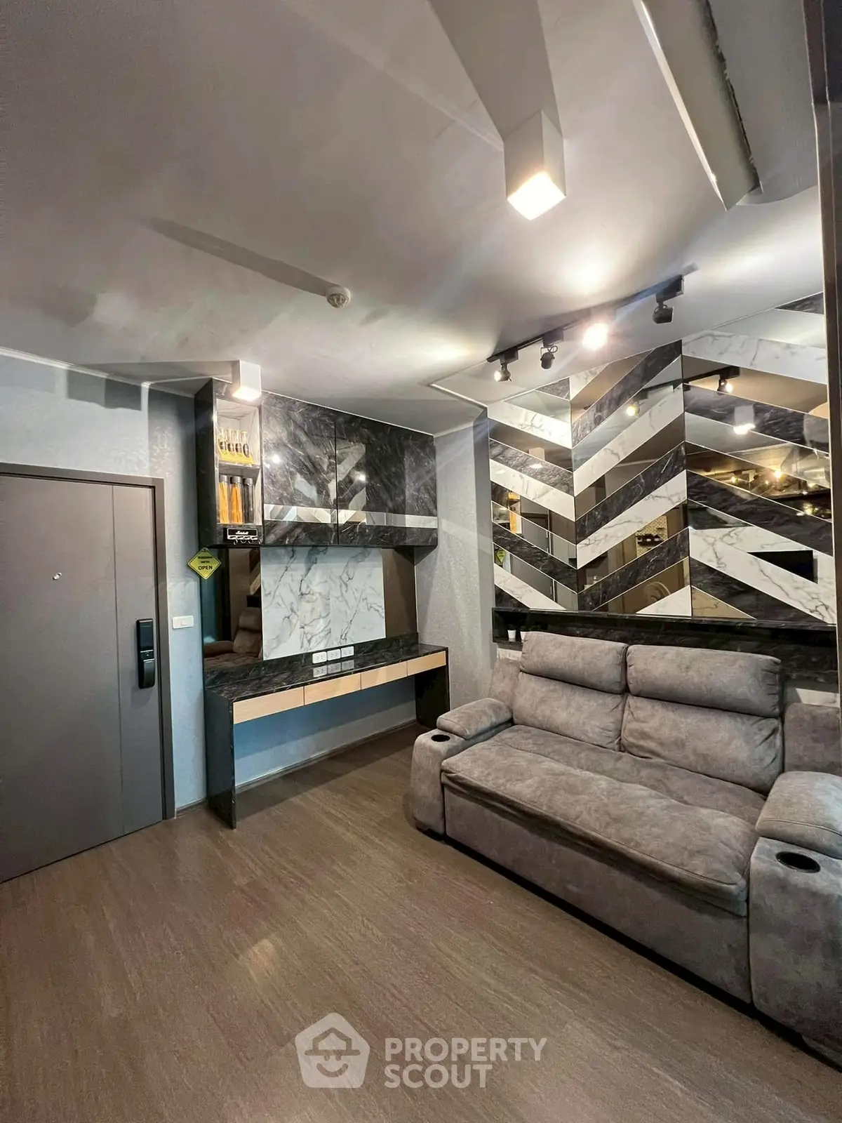 Modern living room with stylish marble wall and cozy gray sofa