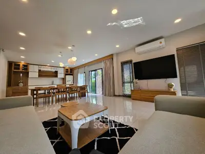 Spacious modern living room with elegant furniture and large TV, perfect for family gatherings.